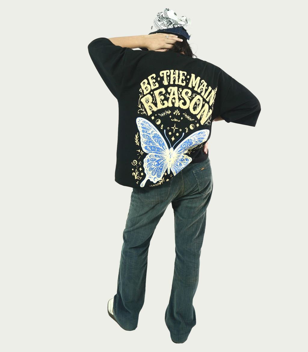 Full back view of TAMRAT black boxy fit graphic t-shirt styled with dark jeans and bandana